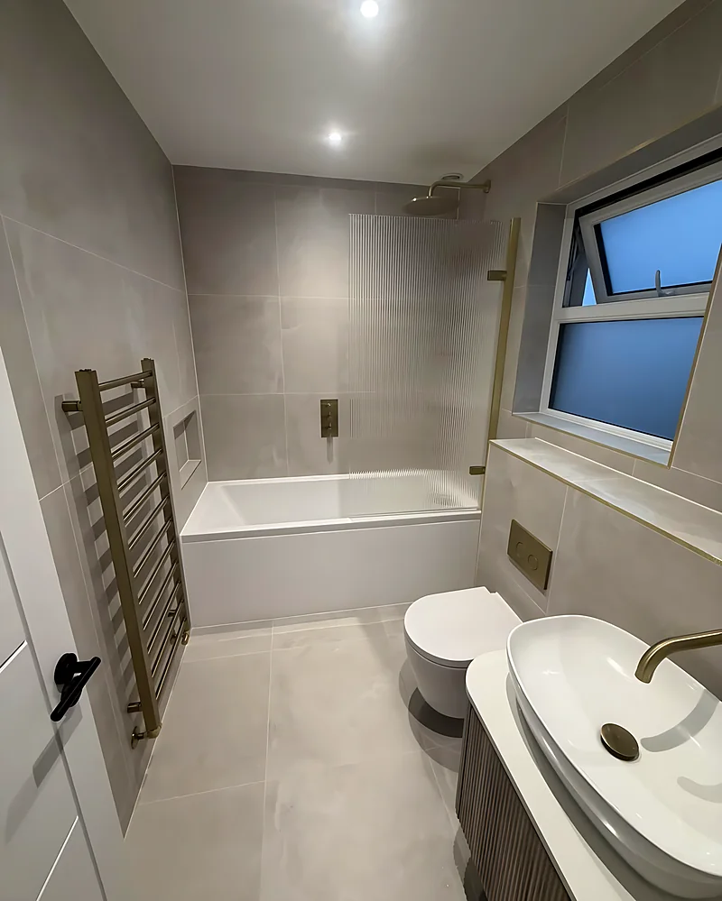 Bath with a brushed brass towel rail