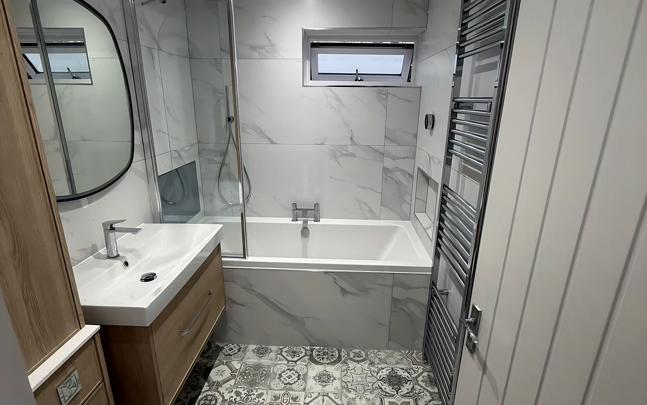 Hatfield Peverel bathroom with a patterned floor, a shower bath and a wood vanity
