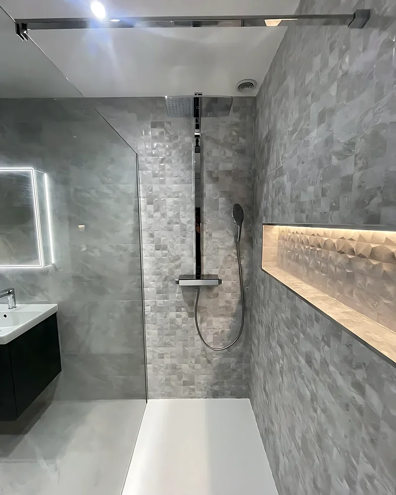 Shower with black fittings and a lit shelf